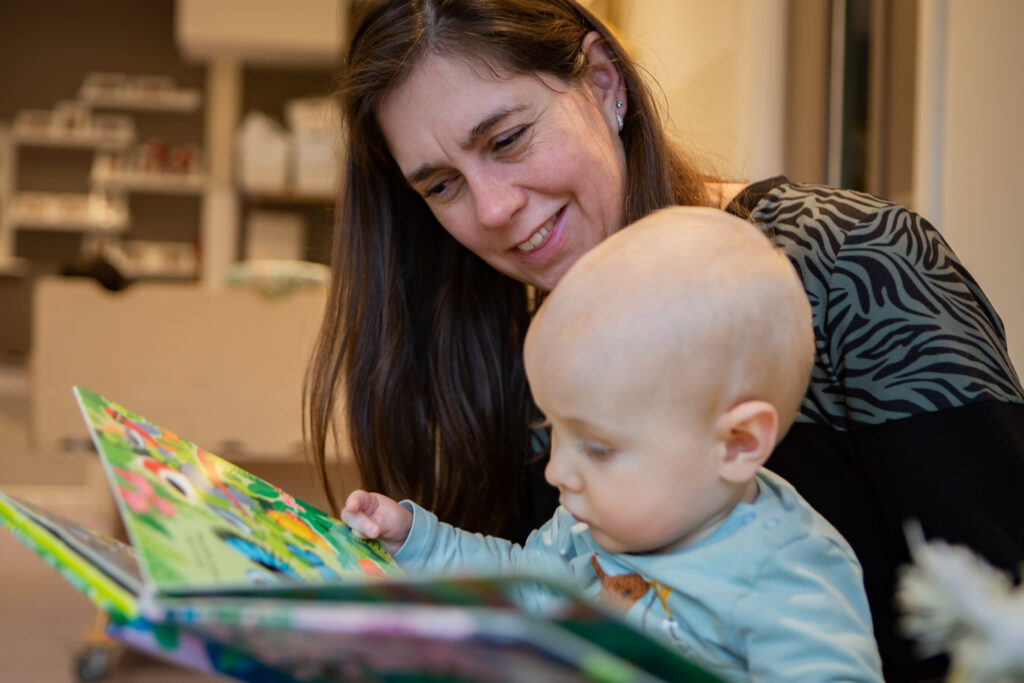 pedagogisch professional en kind lezen samen in een prentboekje