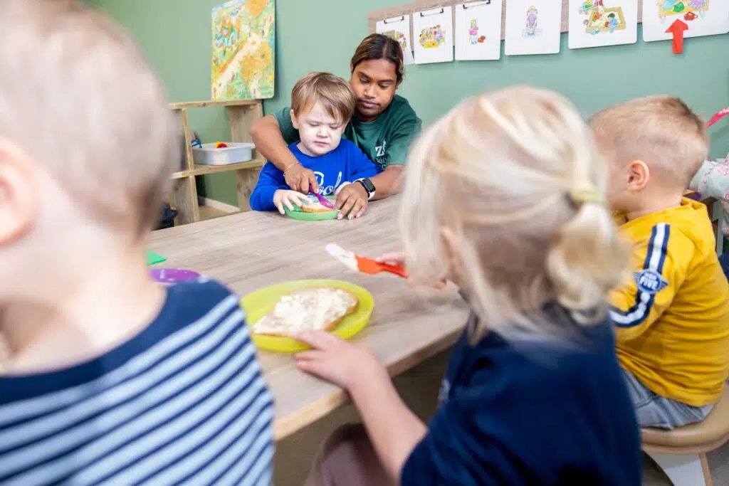 Pedagogisch Medewerker Snijdt Boterham Kinderopvang 1024x683 1